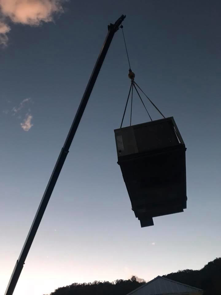A large HVAC unit being lifted by a crane during an installation or replacement project by R & R H.V.A.C in Knoxville, TN.