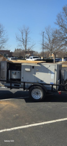 A large commercial HVAC unit loaded on a trailer in a parking lot for Cordells Heating and Cooling in Greenville, SC.
