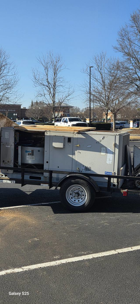 A large commercial HVAC unit loaded on a trailer in a parking lot for Cordells Heating and Cooling in Greenville, SC.
