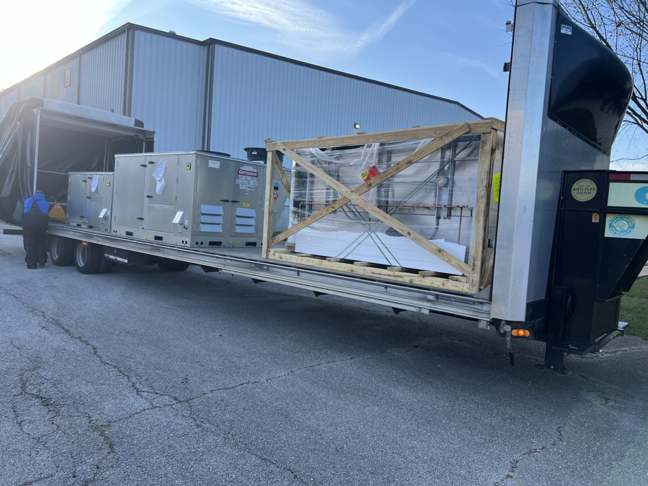 Several large, crated and uncrated HVAC units delivered on a semi-trailer for installation by HBC in Cranston, RI.
