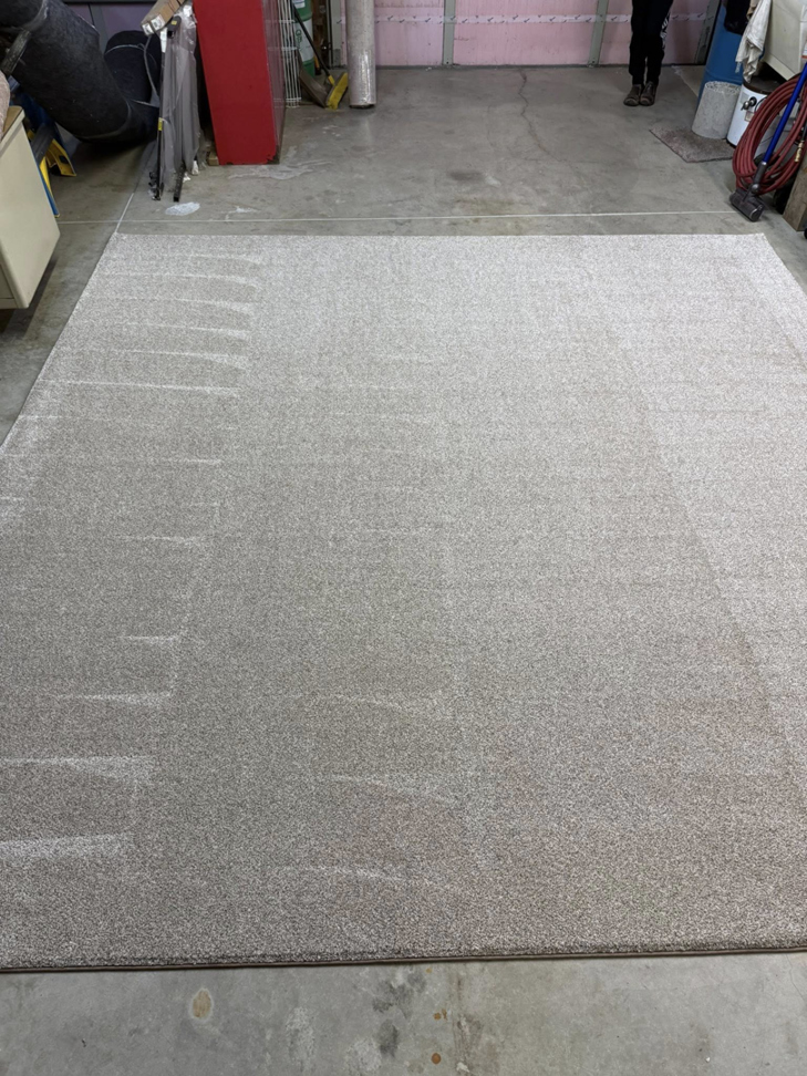 A large light grey area rug with subtle patterns, processed by Rug Edge Binding Company in Spokane, WA