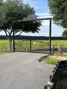 A large black metal farm gate with an overhead arch installed by A-1 Security Fence in Scott, LA.