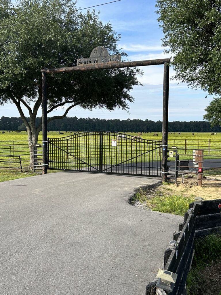 A large black metal farm gate with an overhead arch installed by A-1 Security Fence in Scott, LA.