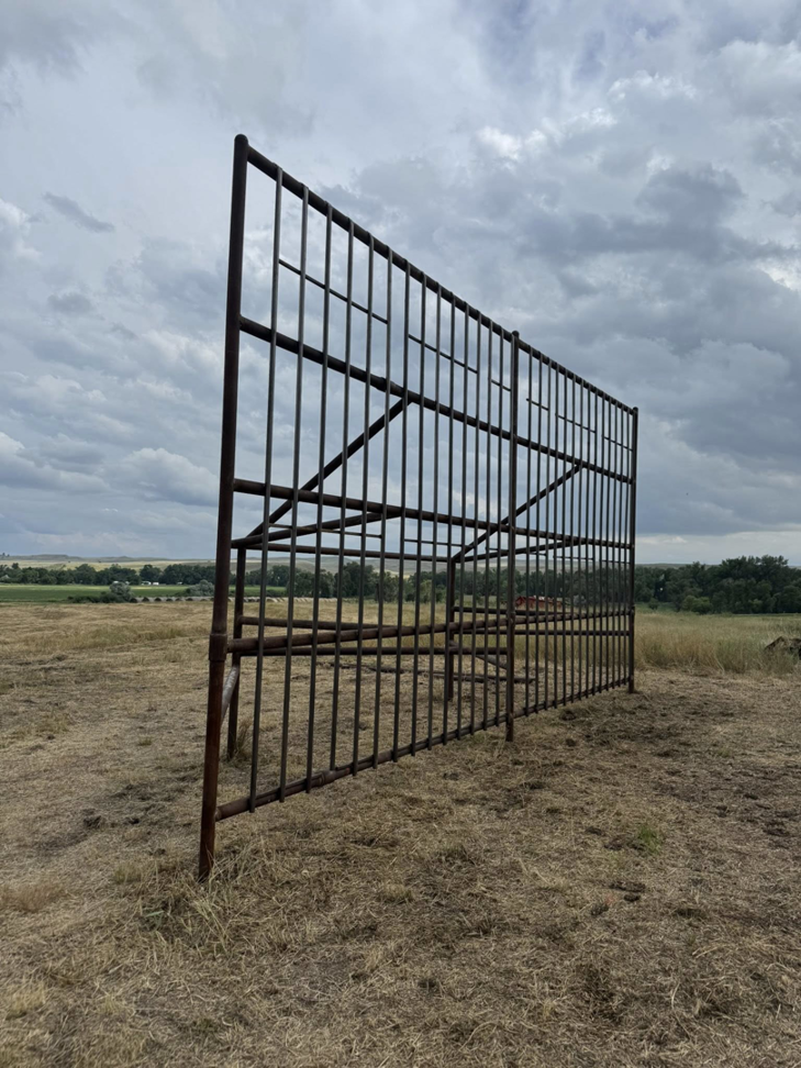 A large, robust metal fence structure standing in a field, built by Deer Creek Ag Services in Ranchester, WY.