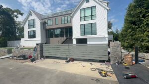 A large modern sliding gate with stone pillars installed by RP Fencing & Gates in Brewster, NY