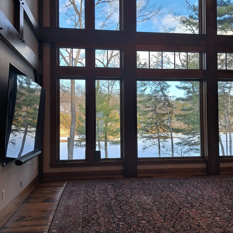A large, intricately patterned oriental rug beautifully placed in a spacious living room by Borokhim's Oriental Rugs in Madison, WI.