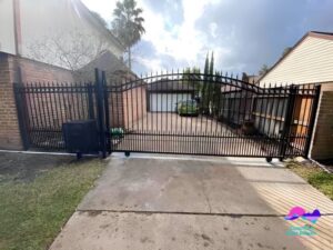 A large ornate black wrought iron driveway gate, showcasing custom gate installation by Coastline Gate Repair in Los Angeles, CA.