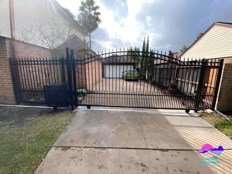 A large ornate black wrought iron driveway gate, showcasing custom gate installation by Coastline Gate Repair in Los Angeles, CA.
