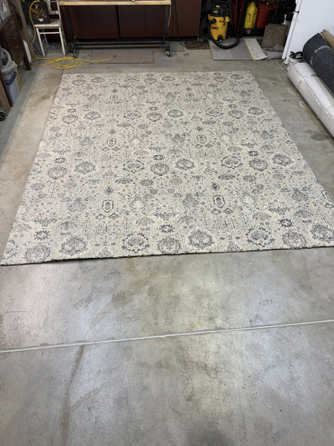 A large patterned area rug laid out on a concrete floor by Rug Edge Binding Company in Spokane, WA