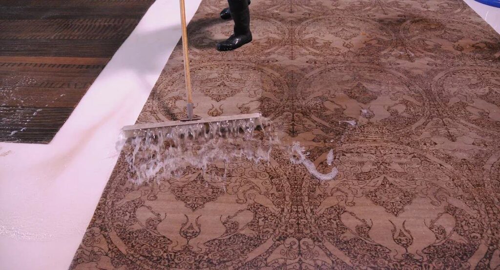 A large patterned rug being thoroughly scrubbed during cleaning at Renaissance Rug Cleaning Inc. in Portland, OR.