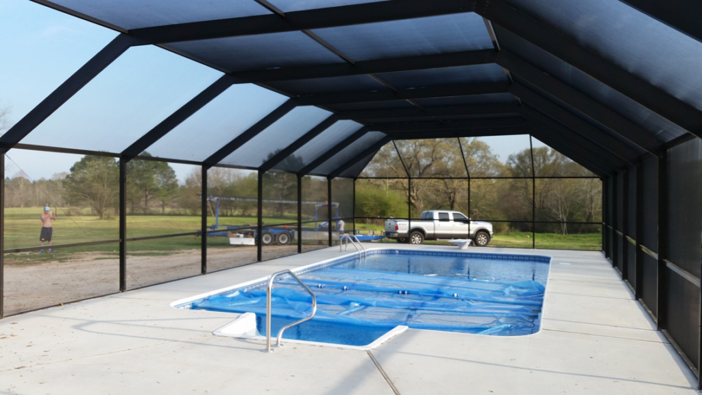 A large pool enclosure with a covered swimming pool installed by Backyard Paradise in Mobile, AL.