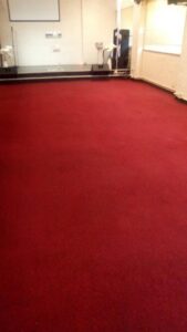 A large, clean red carpet in a commercial or event space, showcasing professional carpet installation or cleaning by Carpets Dirty in Phoenix, AZ