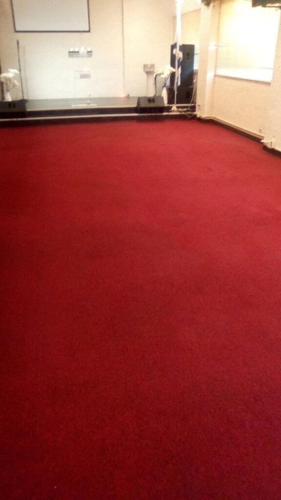 A large, clean red carpet in a commercial or event space, showcasing professional carpet installation or cleaning by Carpets Dirty in Phoenix, AZ