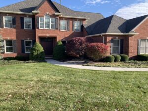 A large residential property with a perfectly manicured lawn and trimmed shrubs by Three Rivers Lawn Care Co. in Fort Wayne, IN.