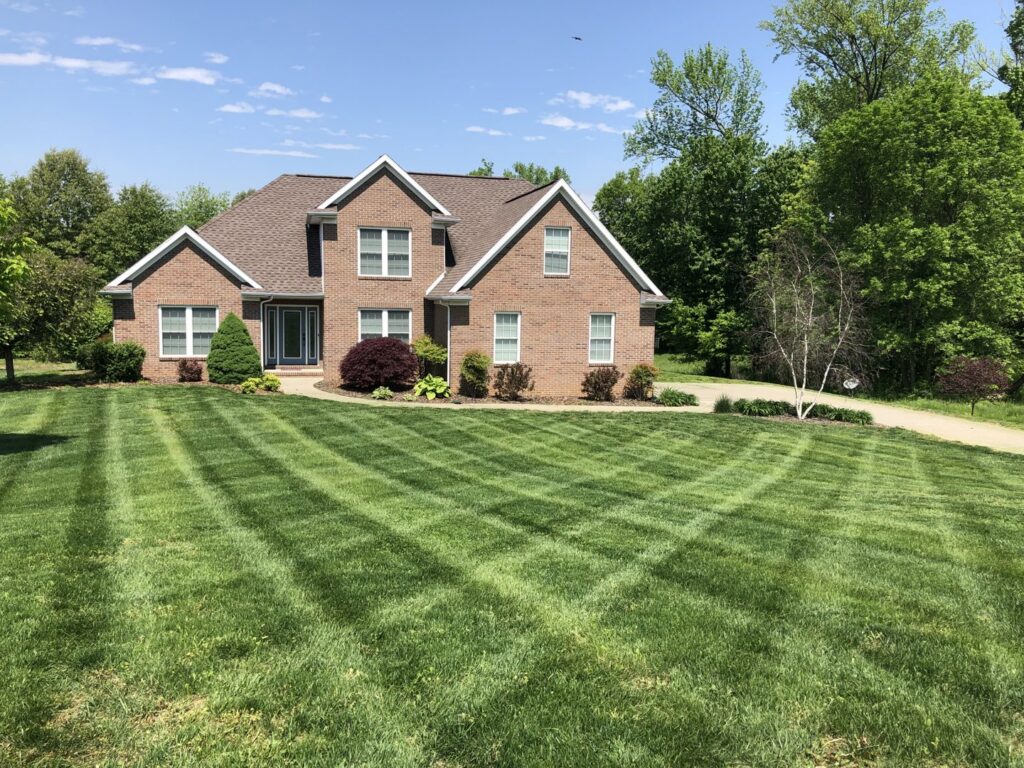 A large residential lawn with a perfectly mowed crisscross pattern by C&R Lawn Care and Property Services in Evansville, IN.