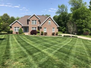 A large residential lawn with a perfectly mowed crisscross pattern by C&R Lawn Care and Property Services in Evansville, IN.
