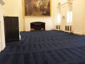 A large room with a blue patterned carpet showing clean lines after service by Get Green Carpet Cleaning CT in West Hartford, CT.