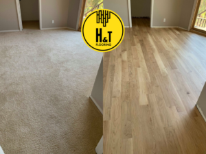 Split image showing old carpet on the left and new hardwood flooring on the right in a large room by H & T Flooring in Clarksville, TN
