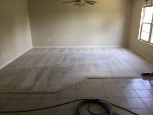 A large room with carpet and tile flooring, showing carpet partially cleaned by C&C Carpet Care LLC in Columbia, MO.