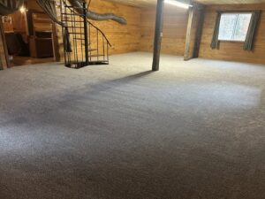 A large room with newly installed light gray carpet and a spiral staircase by BC Quality Flooring in Jeffersonville, IN.