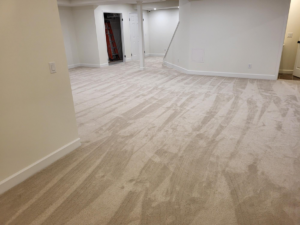 A large room with freshly laid beige carpet by Christie Carpets & Blinds, serving Rochester, NY