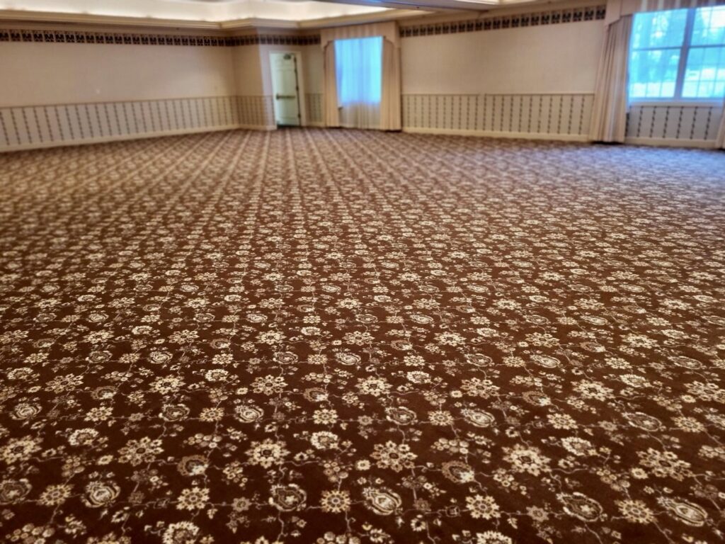 A large room featuring a new patterned brown carpet installation by Christie Carpets & Blinds in Rochester, NY