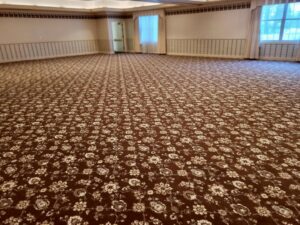 A large room featuring a new patterned brown carpet installation by Christie Carpets & Blinds in Rochester, NY