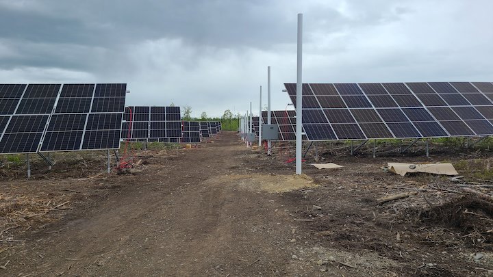 A large-scale solar farm with multiple rows of panels, showcasing renewable energy solutions by Premier Electric LLC in Palmer, AK.
