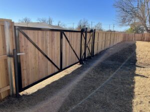 A large sliding wood gate with a sturdy metal frame installed by ProScape Outdoor Construction LLC in Norman, OK.