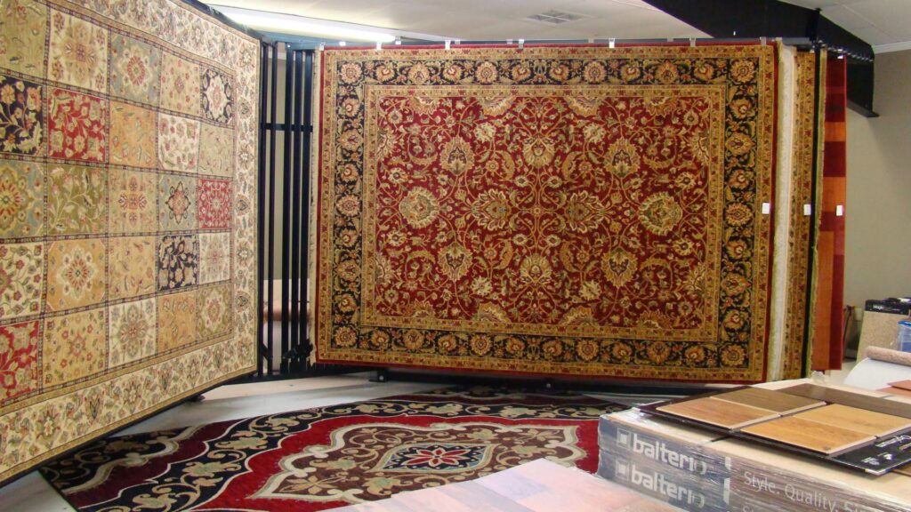 Large traditional area rugs displayed on racks in the D&D Floors and Moore showroom in Huntsville, AL