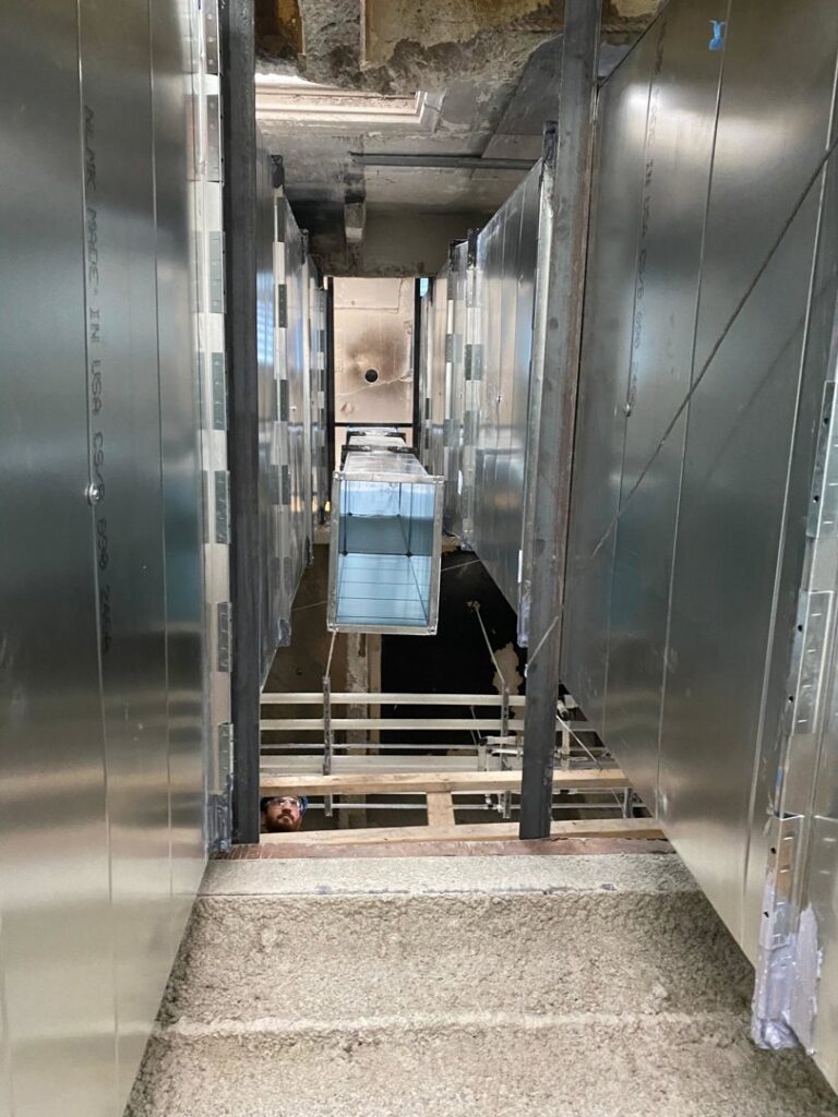 Large vertical HVAC ductwork being installed in a commercial building by Cafco Services in Cincinnati, OH.
