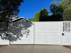 A large white double gate providing secure entry to a property, installed by Harwell Fencing & Gates Inc. in Los Angeles, CA.