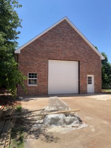 A large white garage door installed on a brick building by 405 Garage Pros in Edmond, OK.