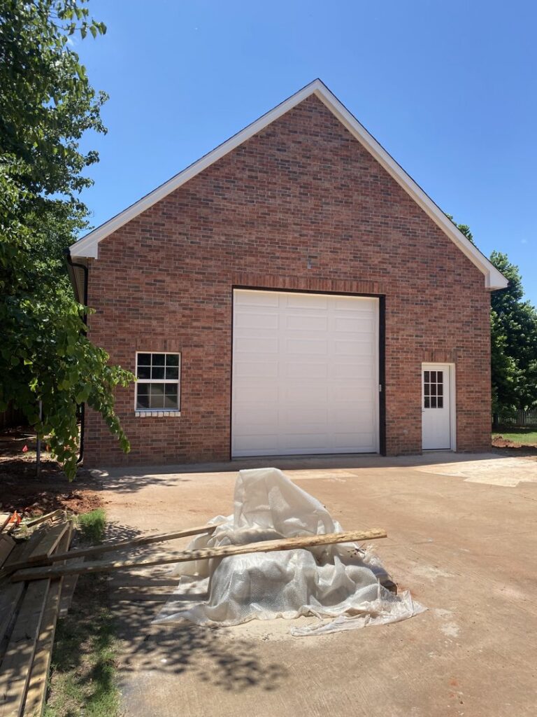A large white garage door installed on a brick building by 405 Garage Pros in Edmond, OK.