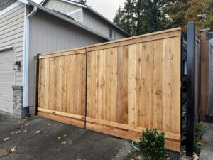 A newly installed large wooden driveway gate, expertly crafted by Fences NW LLC in Spanaway, WA