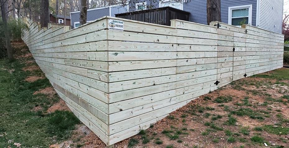 A large wooden retaining wall or privacy fence built on a slope by Big Jerry's Fencing of Boise ID in Holly Springs, NC.