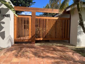 A large wooden gate with vertical slats installed as part of a fence system by Miami Fence Installation Contractors in Miami, FL.