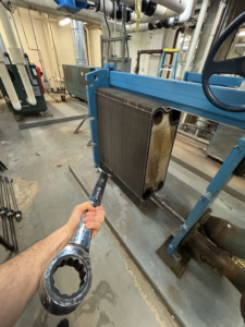 A large wrench being used for commercial HVAC maintenance on a heat exchanger by APEX HVAC Solutions LLC in Frederick, MD.