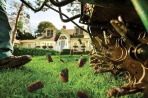 A lawn aerator machine pulling soil plugs during aeration service by Greener Grounds Lawn and Tree in Birmingham, AL