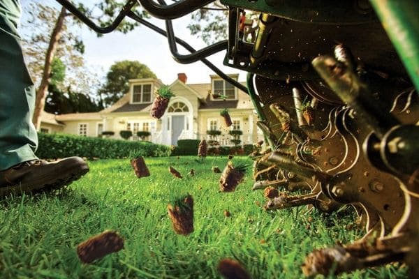A lawn aerator machine pulling soil plugs during aeration service by Greener Grounds Lawn and Tree in Birmingham, AL