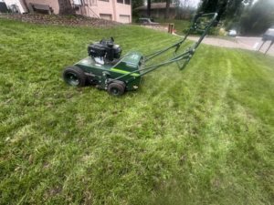 A professional lawn aerator machine positioned on a green lawn, ready for service by Nice Grass Minnesota LLC in Minneapolis, MN.