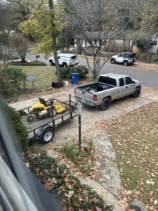 A truck and trailer with a riding lawn mower, ready for a job by Town and Country Grounds Care in Homewood, AL.