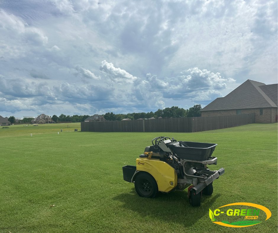 A professional lawn care spreader machine on a large green lawn, ready for treatment by C-Green Lawns in Yukon, OK.