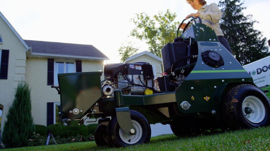 A Lawn Doctor technician operating a professional lawn aerator or seeder in Carmel, IN, providing expert lawn care.