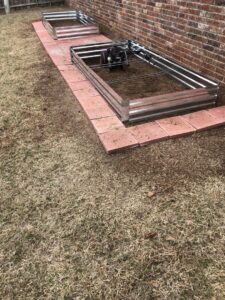 A lawn care worker using a string trimmer for edging and maintenance by A & A Lawn Care Service LLC in Moore, OK.