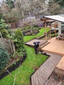 An OregonScapes team member raking leaves and debris from a lawn as part of comprehensive lawn care in Eugene, OR.