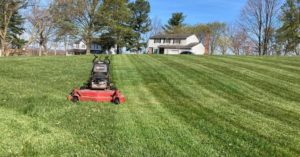 A commercial lawn mower creating perfect stripes on a large lawn by As Green Lawncare and Landscaping LLC in Frederick, MD.