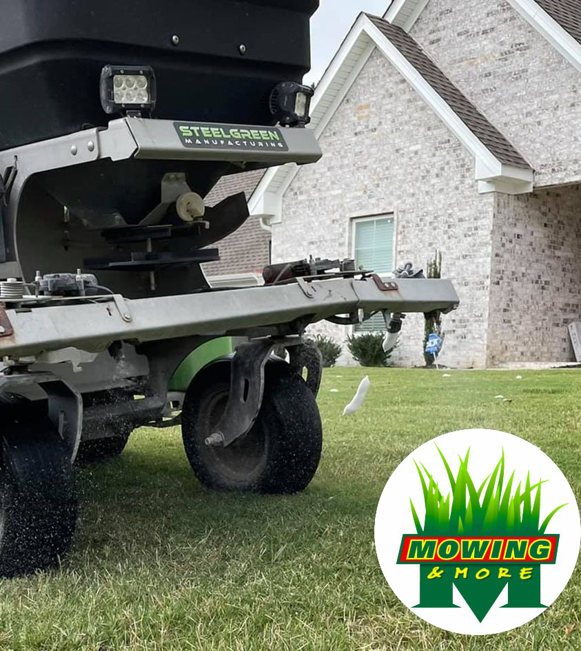 A professional lawn spreader applying weed control treatment to a residential lawn by Mowing and More in Stillwater, OK