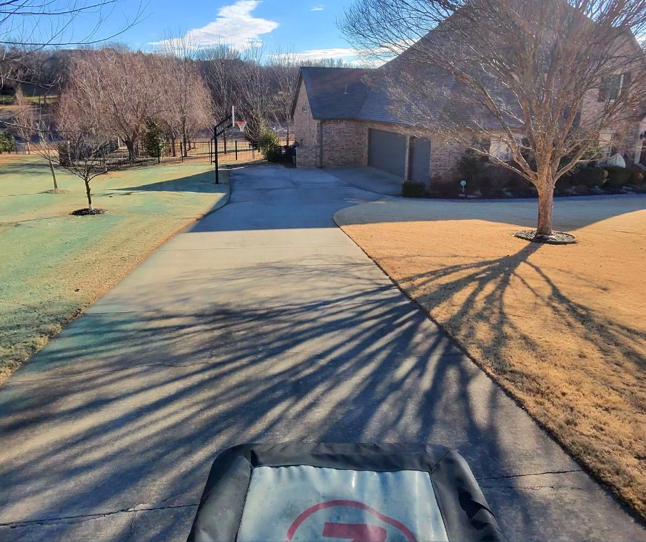 Lawn treatment equipment visible on a residential lawn, showing areas of green and dormant grass by C-Green Lawns in Yukon, OK.