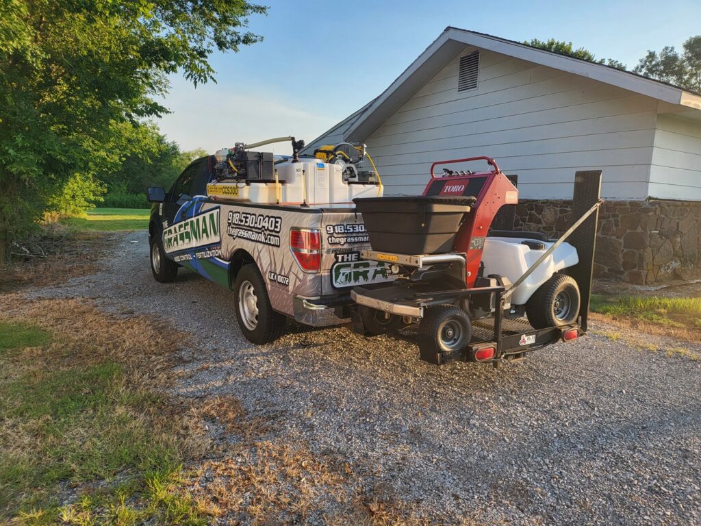 A professional lawn treatment truck with a sprayer and spreader, demonstrating services offered by A&B Lawn Services in Baytown, TX.
